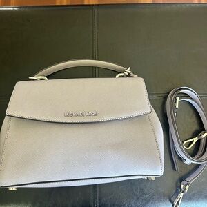 Light lilac Michael Kors crossbody with strap.